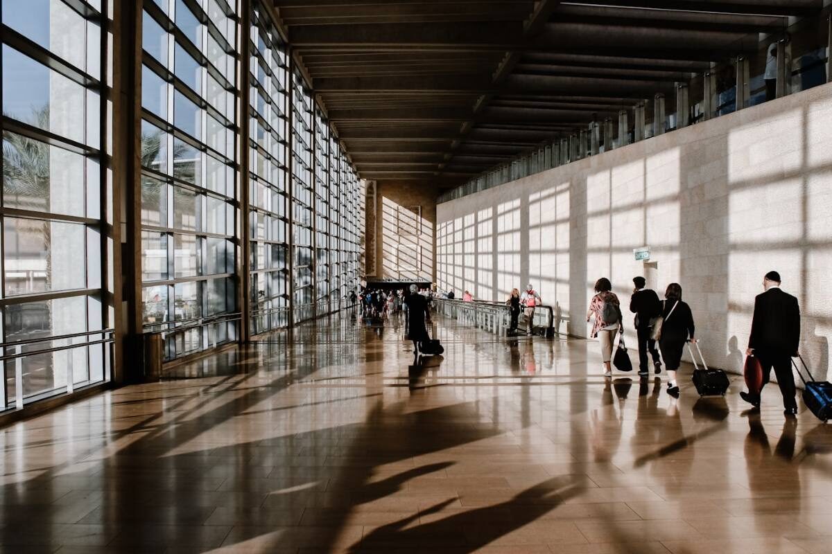 Travelers walking through an airport terminal with luggage