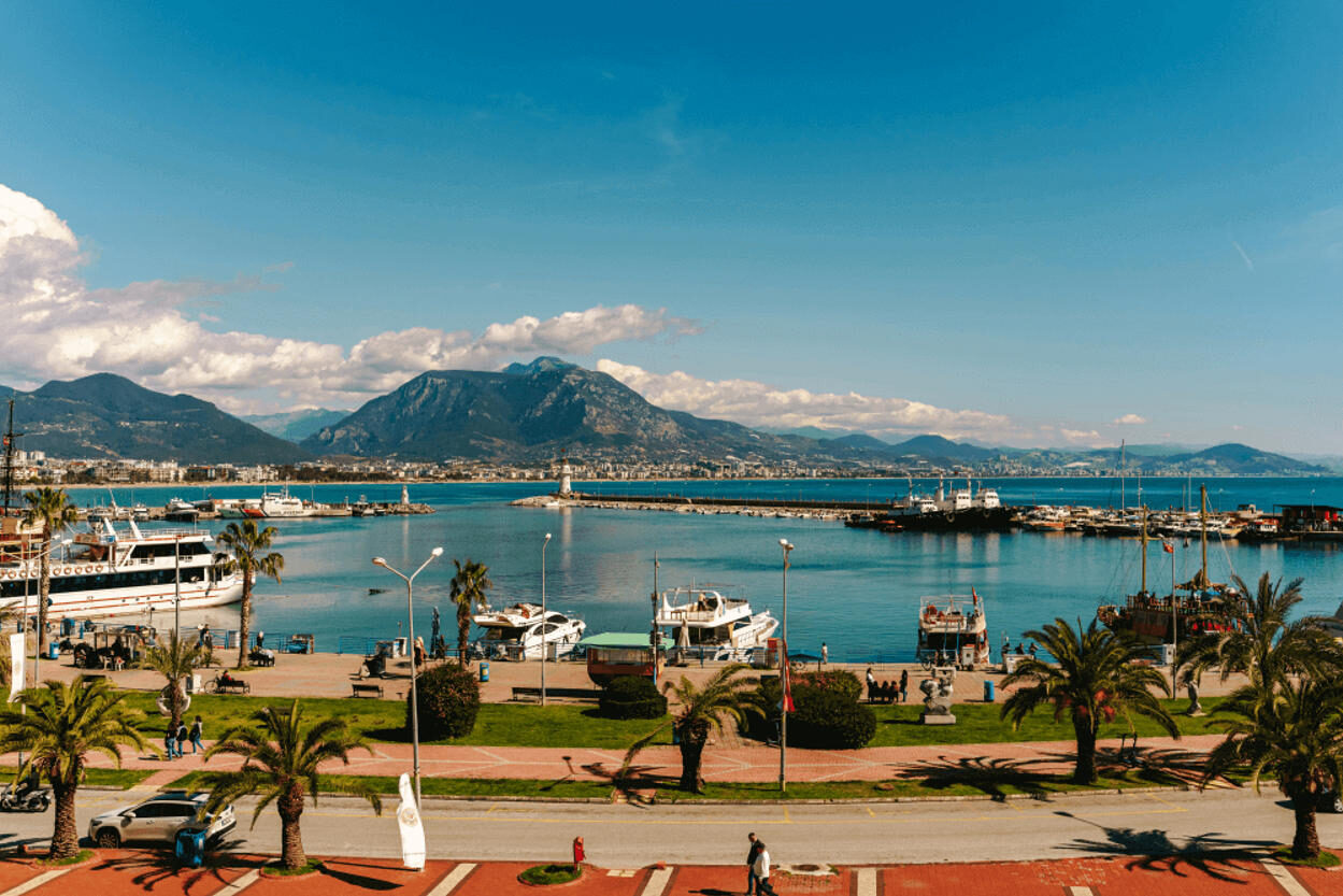 Panoramic view of Antalya’s harbor and mountains — a scenic backdrop for your family vacation. Many family-friendly resorts in Antalya offer this view from their balconies
