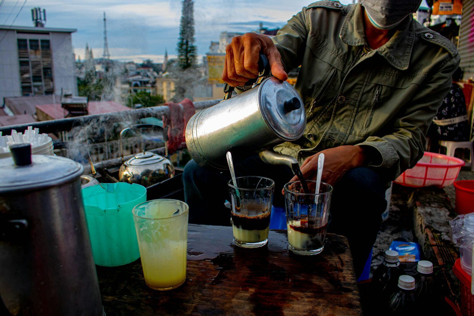 Vietnamese coffee being poured, brewed slowly through a metal phin with condensed milk