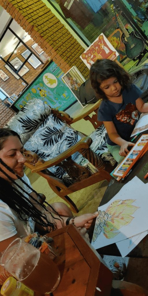 A young girl drawing with colored pencils at Fat Burn Grill & Salads in Talalla, a perfect spot for family evenings