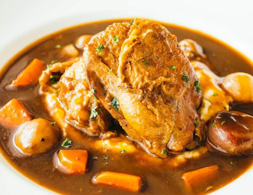 Pepián — Guatemala’s national stew, made with roasted tomatoes, pumpkin seeds, sesame, and achiote, served with chicken in a traditional clay cazuela.
