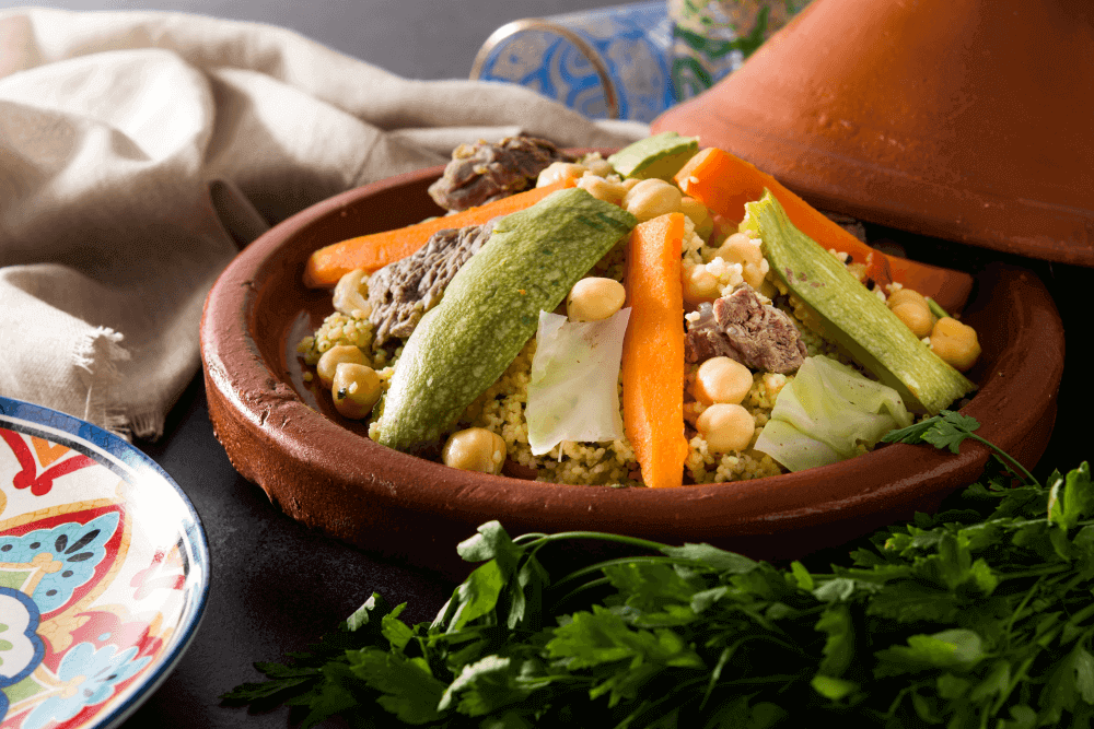 Free things to do in Marrakech: Authentic Moroccan tagine with couscous and vegetables served in traditional clay pot at local street food stall