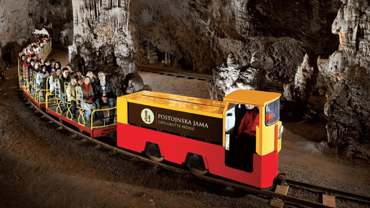 Best European city for families: Family riding electric train through Postojna Cave, one of Europe’s largest cave systems