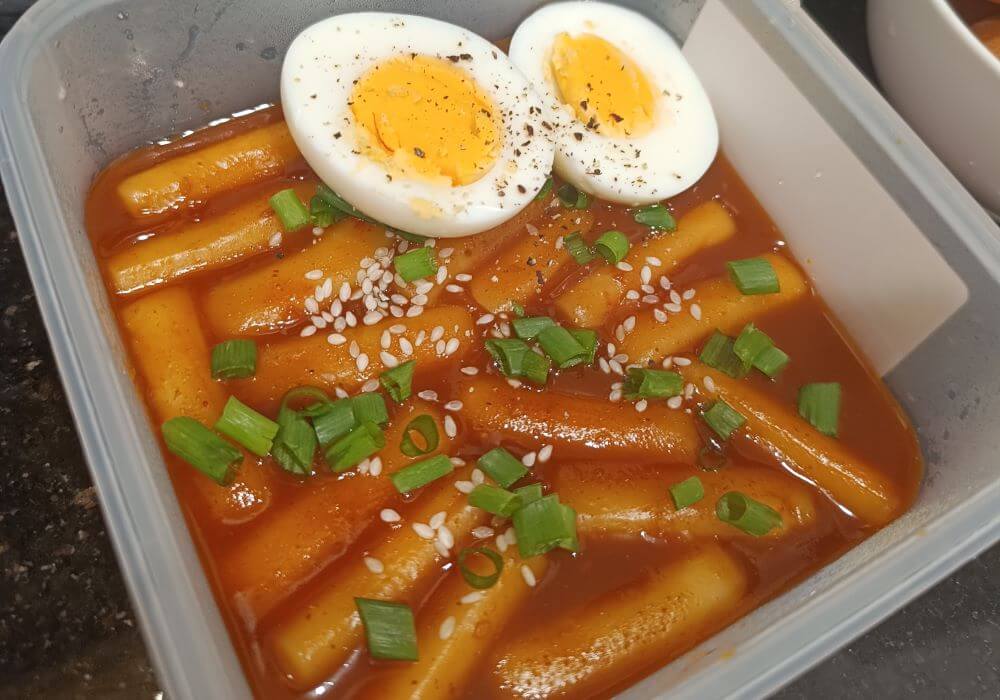 Mild tteokbokki — sweet, chewy rice cakes without chili, served at a Seoul street stall for kids traveling South Korea with family