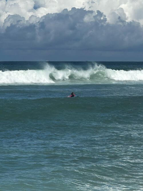 Surfer waiting for a wave in the ocean — perfect moment to choose your surfboard type based on skill and conditions