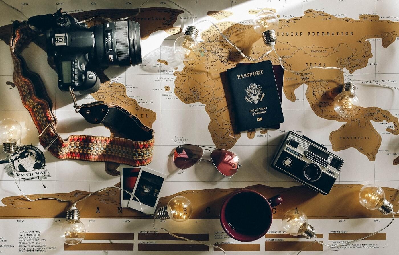 Passport and camera laid out while comparing family travel insurance options
