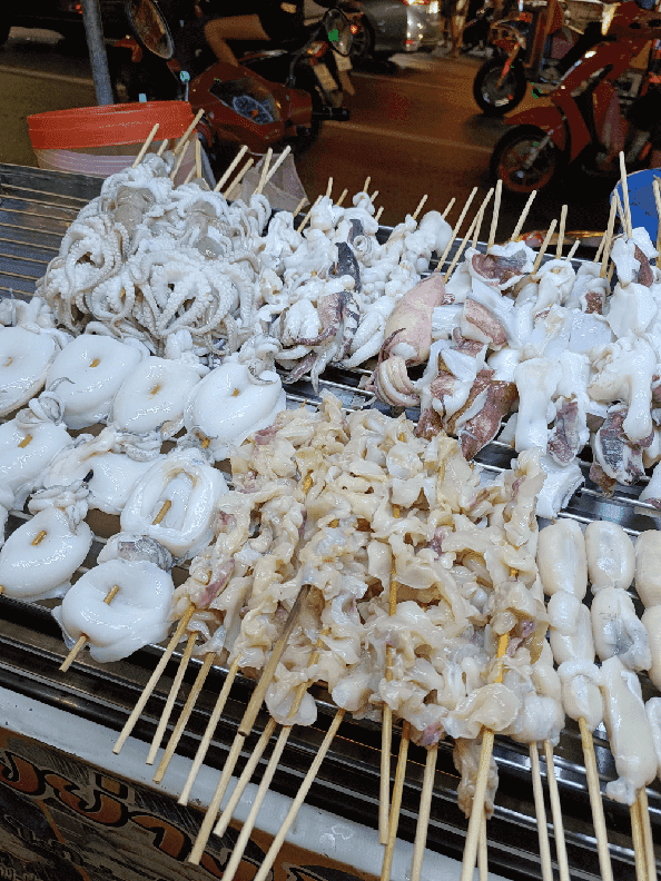 Authentic street food in Bangkok: Grilled squid skewers at Yaowarat night market